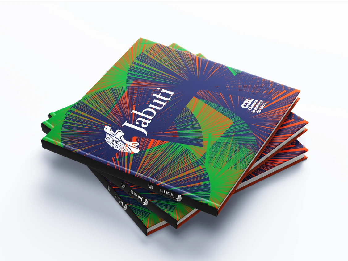 Pilha de catálogos do Prêmio Jabuti 2024 — capa em verde, azul e laranja